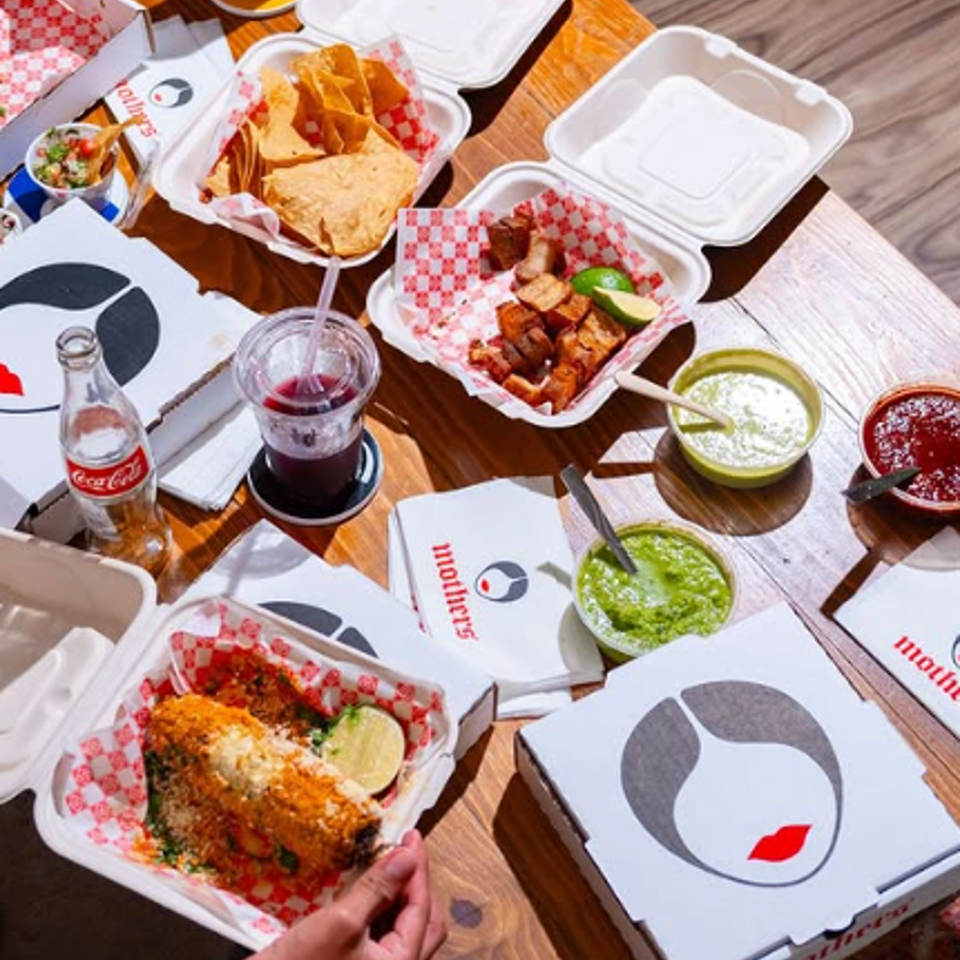 Takeaway meals and salsas spread across a table.