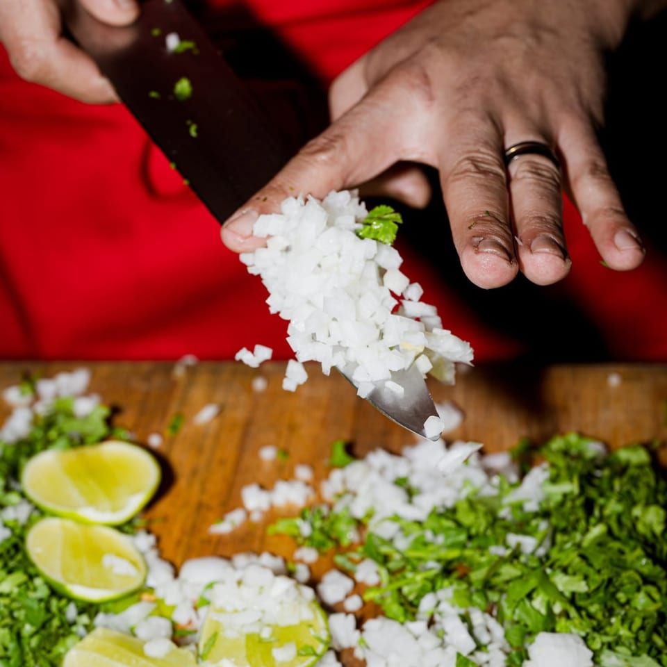 Preparing chopped onions and cilantro with fresh lime.